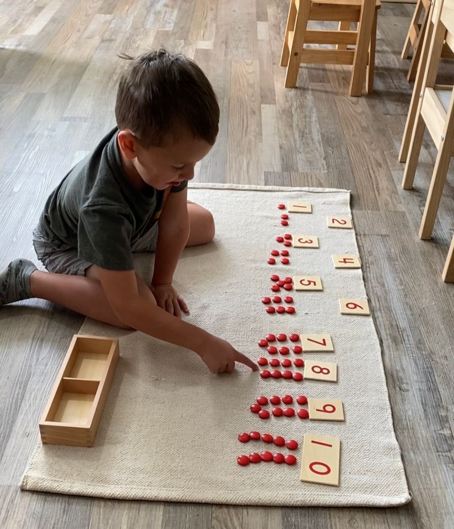 A boy works with red counters